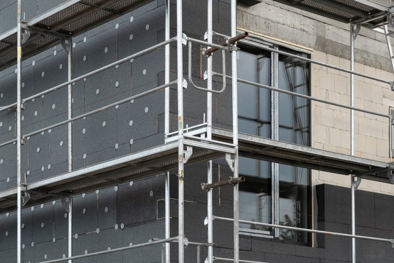 insulating the walls with modern thermal insulation materials. The new house construction process involves Exterior covering is applied at the construction site.